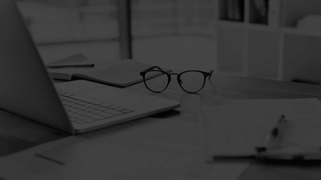 Laptop and a pair of spectacles on a table