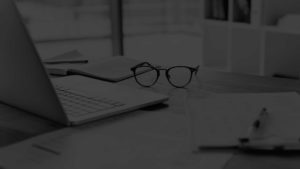 Laptop and a pair of spectacles on a table