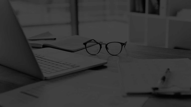 Laptop and a pair of spectacles on a table