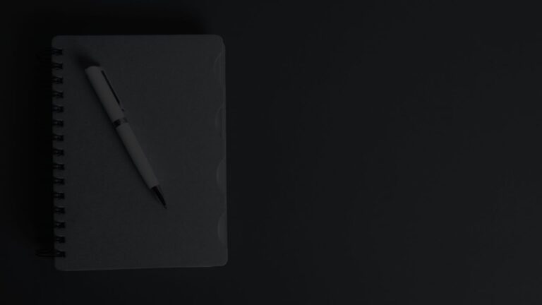 Top down view of a closed notebook and fountain pen