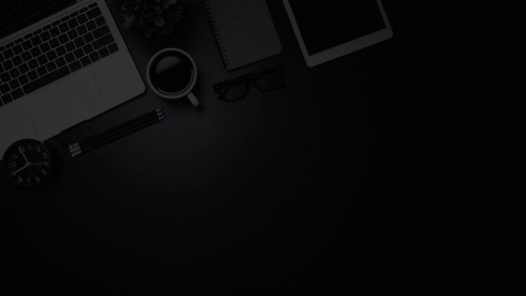Neatly organized flat lay featuring an open laptop, iPad, eye glasses, coffee mug, pencils, and plant