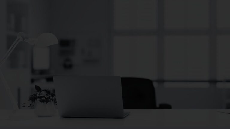 Modern office space featuring a laptop, chair, and desk lamp