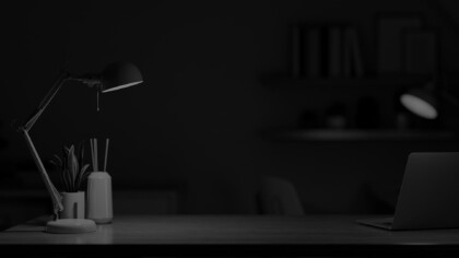 desk with a lamp, laptop, and jar of pencils on it