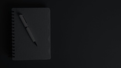 Top down view of a closed notebook and fountain pen