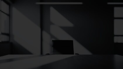 Empty sunlit room with a desk and swivel chair