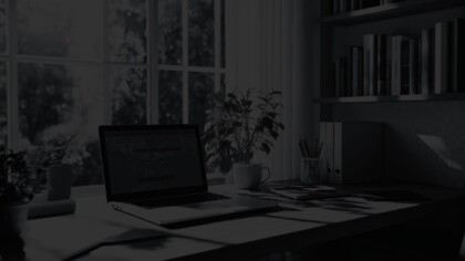 Cluttered office desk positioned by a window with an outdoor view