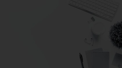 Overhead view of a desk with a keyboard, AirPods, pen, and notebook