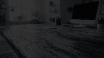 Close-up angled view of a modern wooden desk workspace