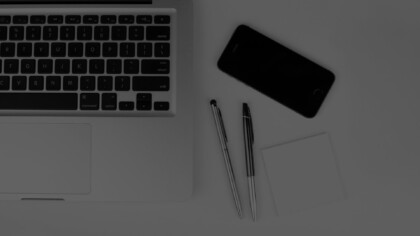 laptop keyboard, two pens and aphone